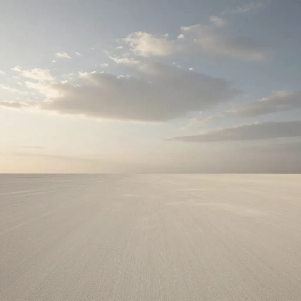High-horizon cloud deck over a remote dawn landscape in soft ivory and stone tones.